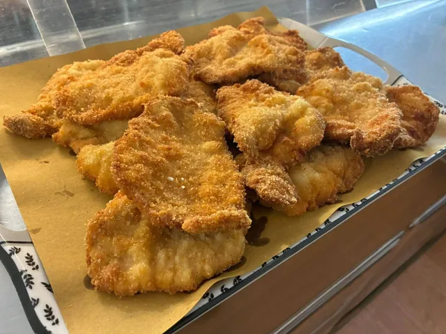 Vassoio di cotolette impanate dorate nella vetrina del Bar Buffet al Gatto Nero di Trieste