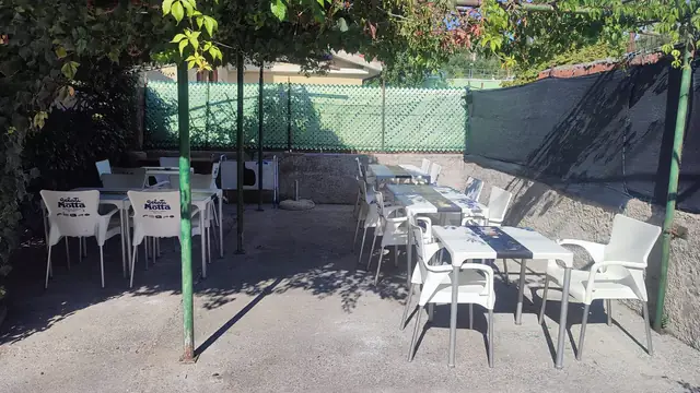I tavoli all'aperto sotto il pergolato del Bar Buffet al Gatto Nero di Trieste